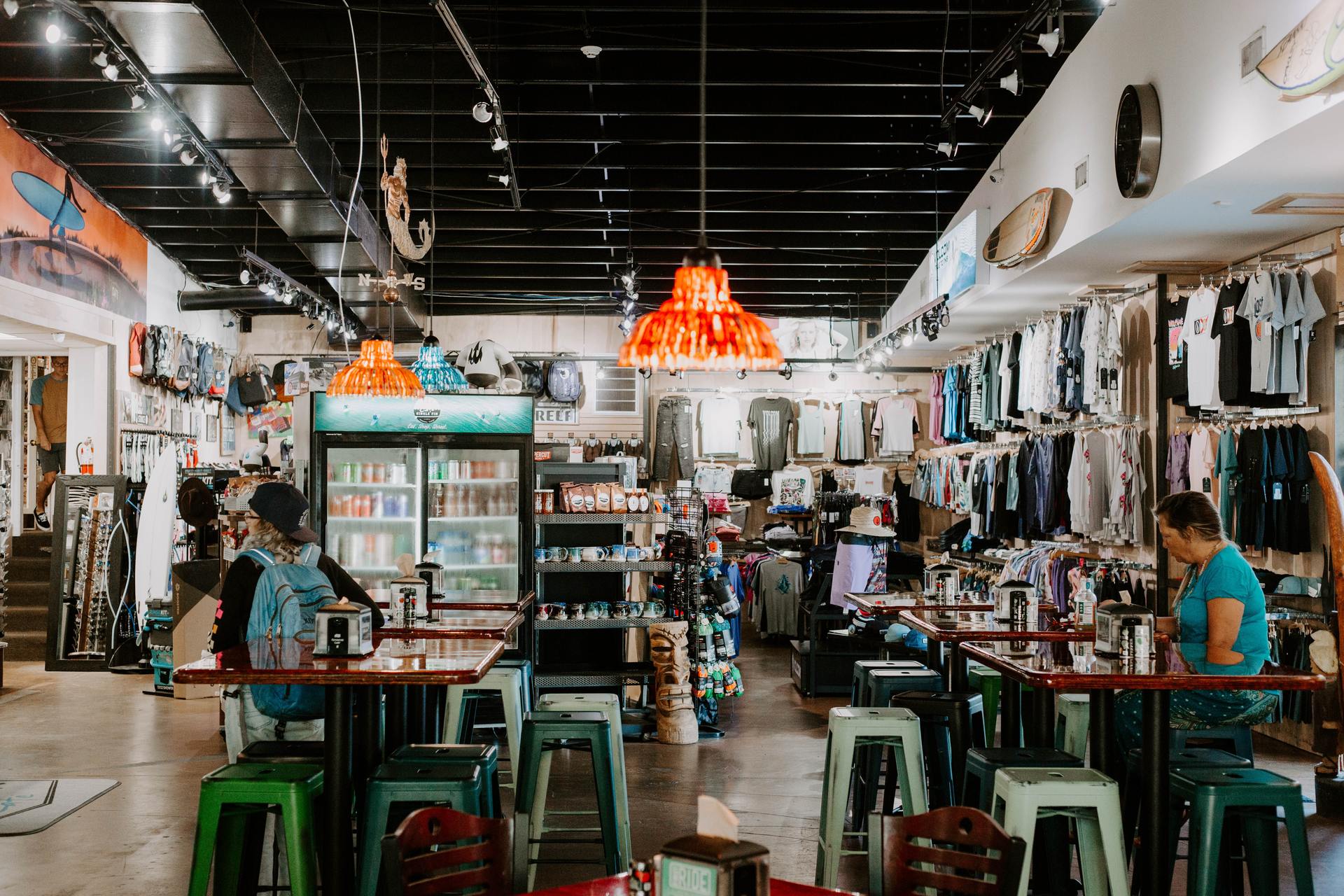 A nice retail store with a woman sitting while wearing a back pack